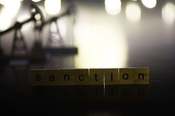 Word Sanctions made of wooden block letters with dramatic lighting and smoke