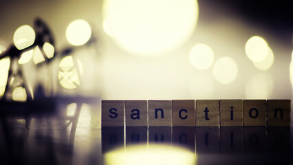 word sanctions spelled in letters on table made of wooden block letters with dramatic lighting and...