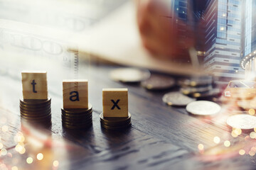 Tax wooden letter on wooden block.Pay tax .Income tax return. Double exposure city, dollar.