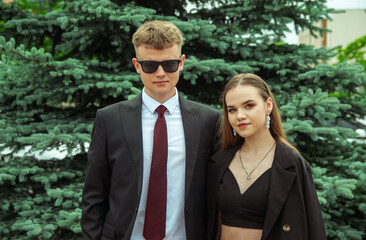 A couple of teenagers in black formal attire.