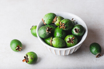 Green feijoa fruits in a ceramic bowl
