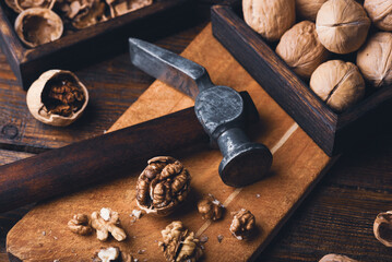 Walnuts and hammer on wooden surface