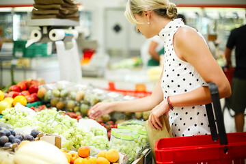 Adult woman choosing fruits in shop