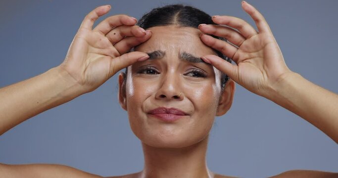 Woman, face and wrinkles on skin in studio, worry and thinking of retinol or hyaluronic acid in mockup. Young model, frown and spa treatment for fine lines, anti aging and collagen by blue background