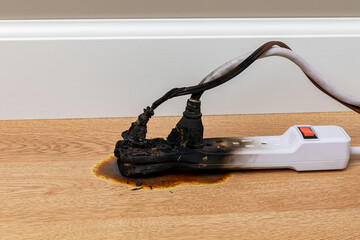 Electrical surge protector outlet and extension cord fire. Electricity safety, fire hazard and circuit overload concept.