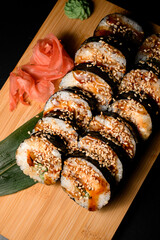 Close-up of sushi rolls covered in brown sauce and sprinkled with sesame seeds