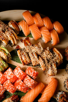 Top view partial set of different sushi rolls with different types of fish, avocado and caviar
