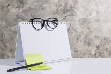 empty side of desk calendar and blank notes, glasses, pen. suitable for your schedule, gray...