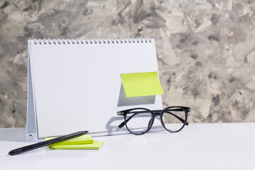 blank desk calendar template, green note paper, pen, glasses, user mockup suitable business theme, studio gray abstact