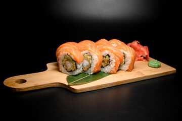 Philadelphia salmon sushi rolls on banana leaf, wasabi and red ginger