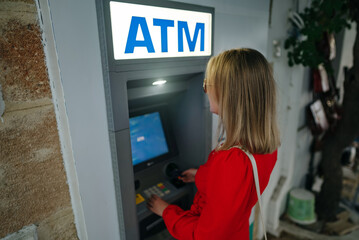 Woman using ATM on the street.
