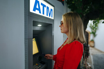 Woman using ATM on the street.