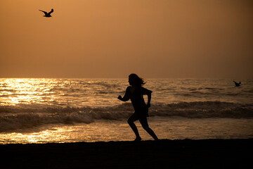 silhouette of a person running on the beach