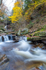 Cascade of waterfalls in a mountain gorge, fast flowing water, long exposure