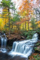 Fototapeta na wymiar Cascade of waterfalls in a mountain gorge, fast flowing water, long exposure
