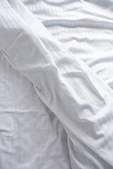 wrinkled white striped bed linen