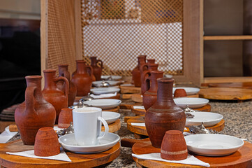 Turkish black cumin coffee prepared to be served on the table and earthenware water pots next to it.