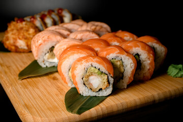 Side view set of sushi rolls: focus in foreground on salmon philadelphia rolls