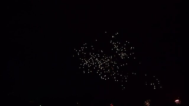 Fireworks exploding in various colors in the dark night sky during a celebration. 4K clip suitable as background.