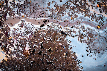 Gasoline spill on asphalt in a car park as a texture or background.
