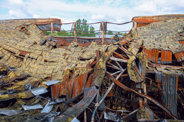 Destroyed industrial building. Insulated roof structures of an industrial building after fire and...