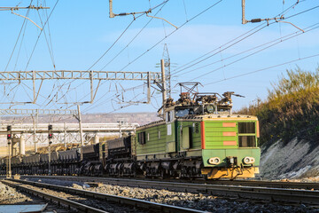 Industrial electric locomotive alternating current pulls opened freight dump rail cars