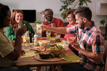 Group of friends from different origins toasting and celebrating eating together. Concept: happiness