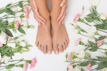 Obraz na płótnie Canvas Beautiful female feet with flowers in the background.