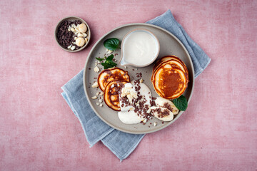 Traditional American Pancakes with banana honey cream, macadamia nuts and chocolate crumbles served...