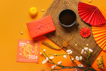Golden dragon figure with greeting card, gift box and decor on orange background. Chinese New Year...