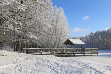 Wooden pier in the snow on a winter lake.