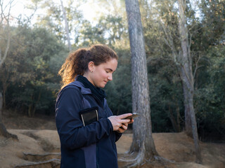 Woman Checking Smartphone During Outdoor Activity in Forest