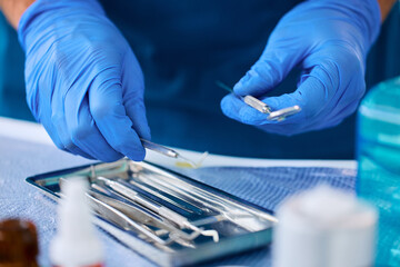 Close up of stomatologist preparing dental tools for teeth examination.