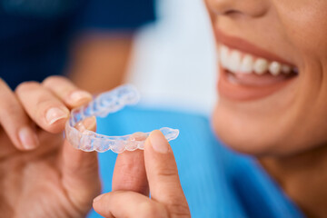 Close up of woman using orthodontic night guard for her teeth.