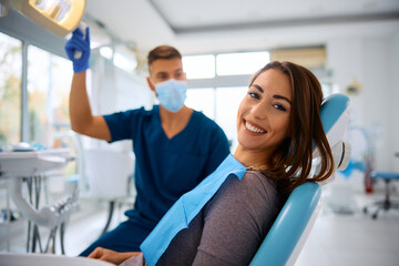 Happy woman having dental treatment at dentist's office and looking at camera.