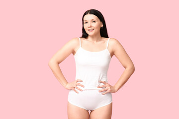 Fototapeta na wymiar Body positive woman in underwear smiling on pink background