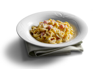 Tortellini soup bowl with cream and ham on white background