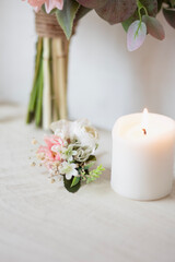 Fototapeta na wymiar white groom boutonniere , ribbon and candle in one. wedding theme