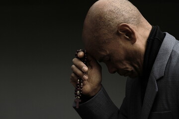 praying to god Caribbean man praying with black background with people stock photo	