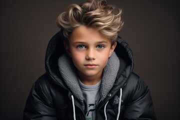 Portrait of a little boy in a black jacket. Studio shot.
