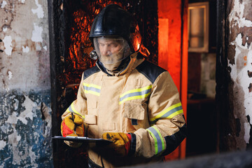Fireman inspector uses clipboard and conducts investigation to determine circumstances of fire in...