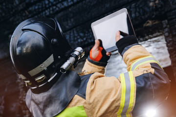 Fireman inspector officer inspects burnt house, take photo on tablet for report of investigating...
