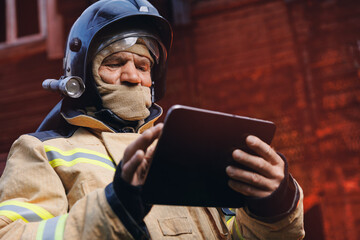 Fireman inspector officer inspects burnt house, take photo on tablet for report of investigating...
