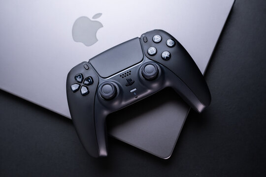 BERLIN , GERMANY - JANUARY 14 2024: Get a detailed view of the advanced DualSense PS5 controller, ideal for immersive gaming experiences on your Apple MacBook Pro in sleek space black.