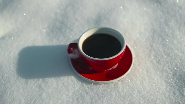 Red hot coffee cup on snow background outdoors, top view. cold morning. 