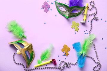 Carnival masks with party horns and decor for Mardi Gras celebration on lilac background