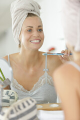 woman with towel on head going to brush teeth