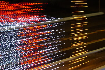 Red, white and yellow light trails on a black background.