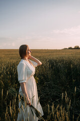A man wearing a white dress standing in a field of tall grass. 5691