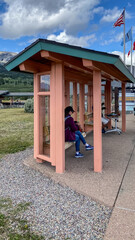 Woman Waiting for the Tour Bus in Glacier National Park